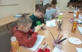 Uczestnicy zajęć tw&oacute;rczych wykonujący walentynkowe kartki. 