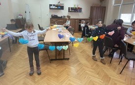 Uczestnicy zajęć tw&oacute;rczych w M-GOK wykonujący walentynkowe girlandy.
