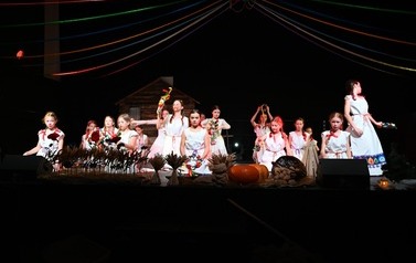 Grupa taneczna z M-GOK Osiek prezentująca taniec podczas spektaklu "Cztery Pory Tradycji", tancerki ubrane w długie białe suknie.