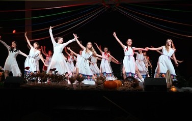 Grupa taneczna z M-GOK Osiek prezentująca taniec podczas spektaklu "Cztery Pory Tradycji", tancerki ubrane w długie białe suknie.