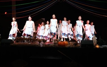 Grupa taneczna z M-GOK Osiek występująca podczas spektaklu "Cztery Pory Tradycji" ubrani w ludowych strojach. 