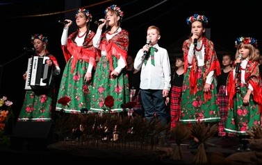 Grupa wokalna z M-GOK Osiek występująca podczas spektaklu "Cztery Pory Tradycji" ubrani w ludowych strojach. 
