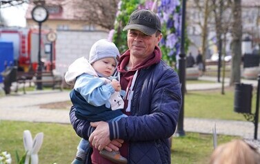 Mieszkaniec osieka wraz z dzieckiem na rękach podczas śniadania wielkanocnego w Osieku. 